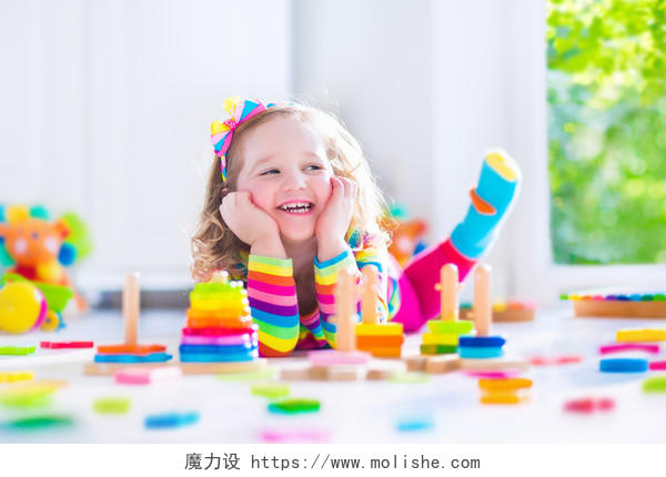 小孩在玩学龄前的木制玩具微笑的小孩